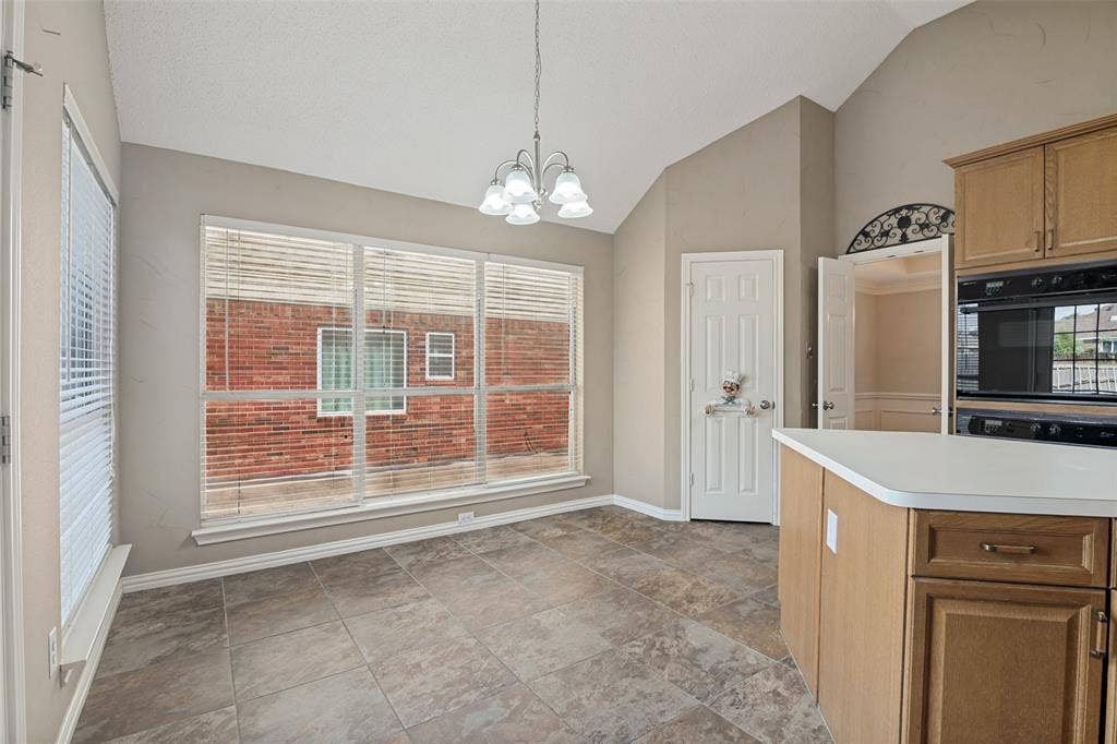 1909 Blackfoot Trail, Mesquite, TX 75149 Vaulted ceilings, large picture window with natural light, tile flooring, built-in dual wall oven, and hanging multi-light chandelier