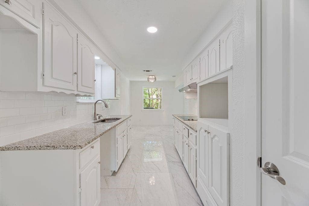 5614 University Hills Boulevard, Dallas, TX 75241 Kitchen featuring white cabinetry, stone-finish countertops, subway tile backsplash, recessed lighting, and large-format tile flooring