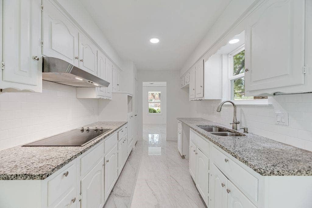 5614 University Hills Boulevard, Dallas, TX 75241 Kitchen featuring white cabinetry, stone countertops, a stainless steel range hood, an electric cooktop, and a dual-basin undermount sink with a gooseneck faucet