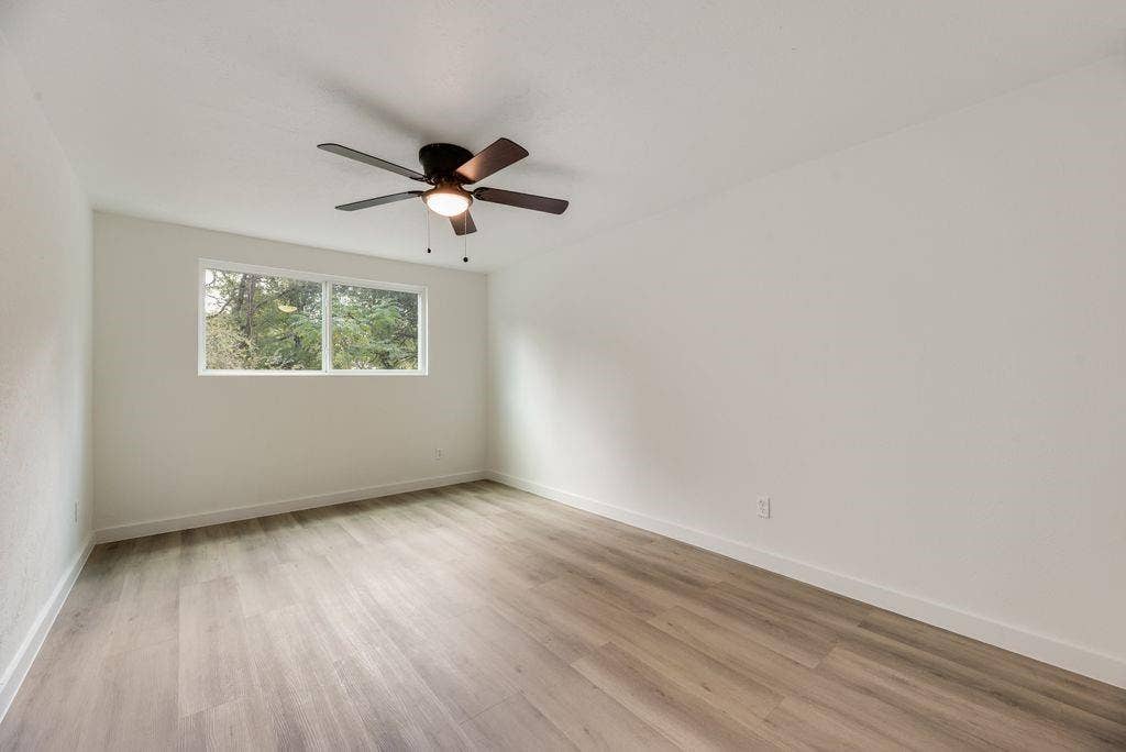 5614 University Hills Boulevard, Dallas, TX 75241 Room featuring wood-finish flooring, a horizontal slider window, and a ceiling fan with integrated lighting
