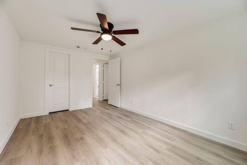 5614 University Hills Boulevard, Dallas, TX 75241 Room featuring wood-finish flooring, a central ceiling fan with integrated lighting, and two-panel interior doors