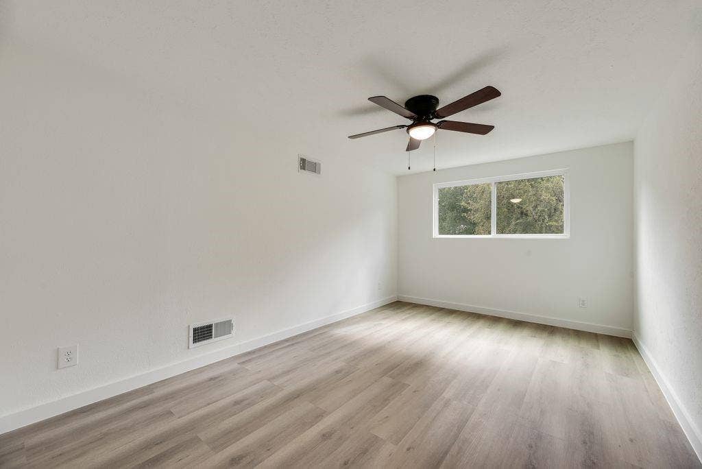 5614 University Hills Boulevard, Dallas, TX 75241 Room featuring wood-finish flooring, white walls, and a ceiling-mounted light fixture with a fan