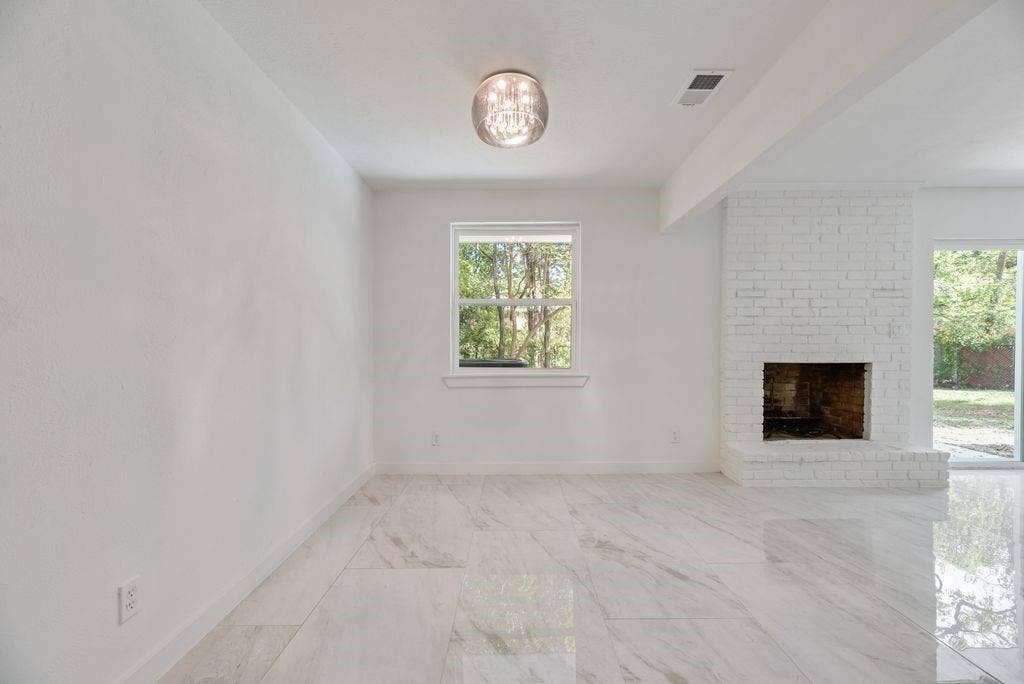 5614 University Hills Boulevard, Dallas, TX 75241 White-painted brick fireplace, polished stone-finish tile flooring, and a spherical flush-mount light fixture