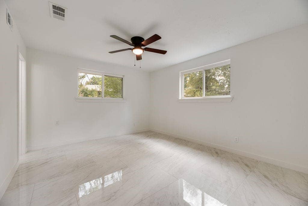 5614 University Hills Boulevard, Dallas, TX 75241 Polished stone-finish flooring, dual windows, and a central ceiling fan with integrated light fixture