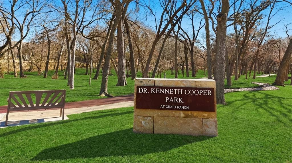 Experience Dr. Kenneth Cooper Park in Craig Ranch, featuring scenic wooded surroundings and rubberized jogging trails, perfect for morning runs or leisurely afternoon strolls.
