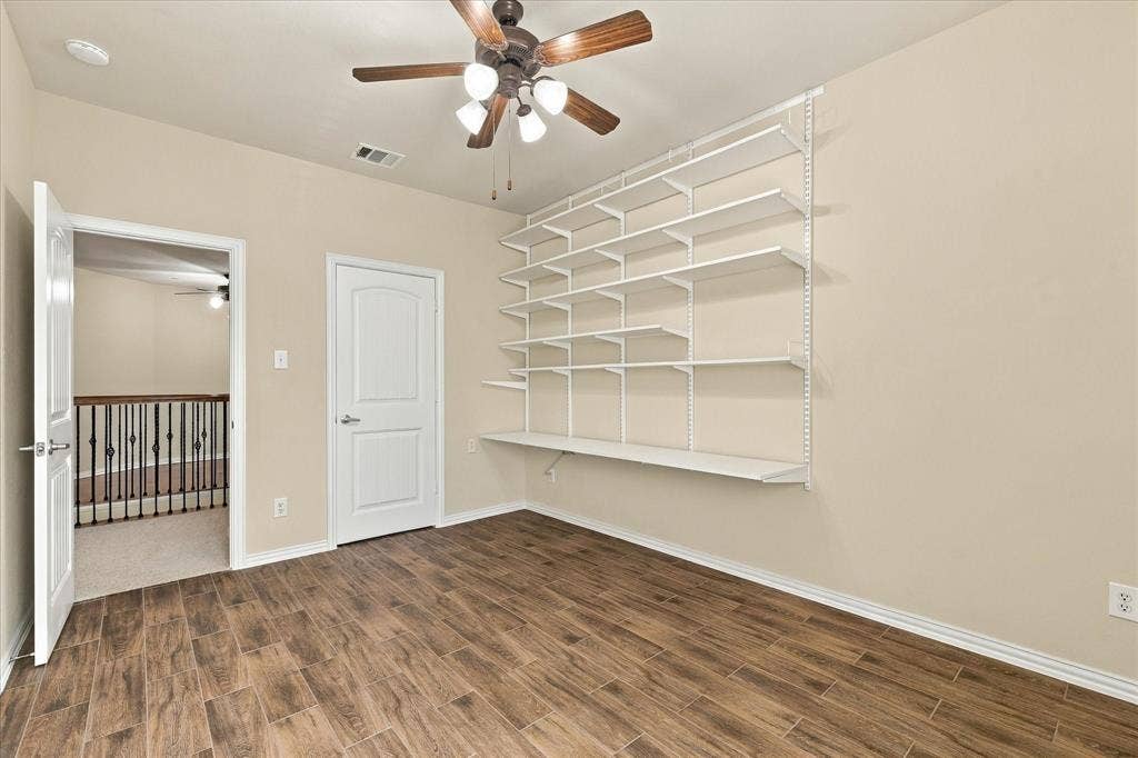 Flexible secondary bedroom with attractive NEW wood like tile flooring and built-in shelving, ideal for home office, creative studio, additional bedroom, or guest retreat.