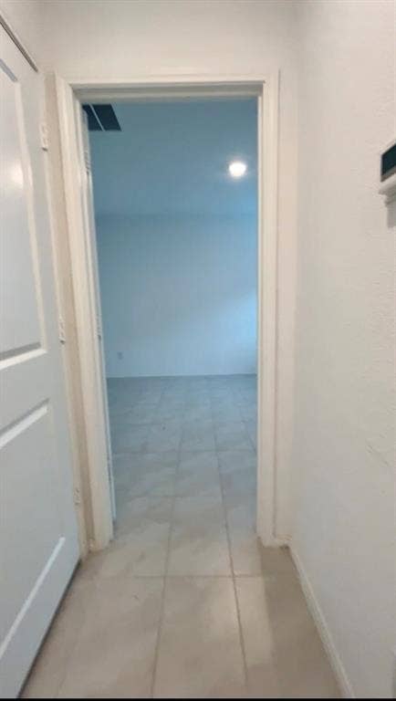 Interior doorway featuring a crisp white door frame and large-format tile flooring