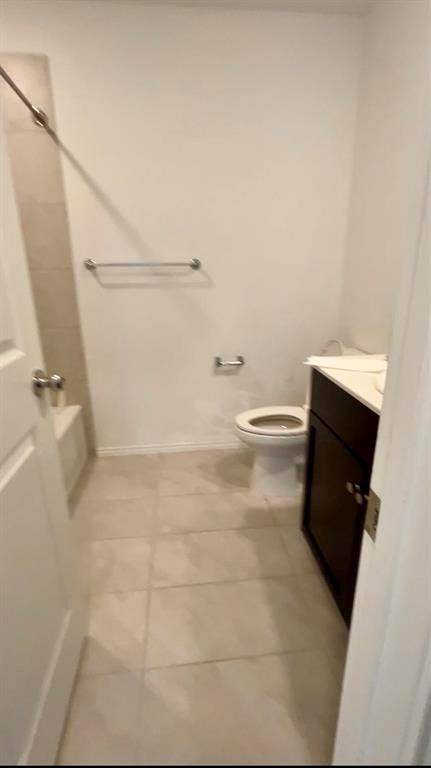 Bathroom featuring a tub-shower combination with tiled surround, tile flooring, vanity with countertop, and brushed nickel hardware