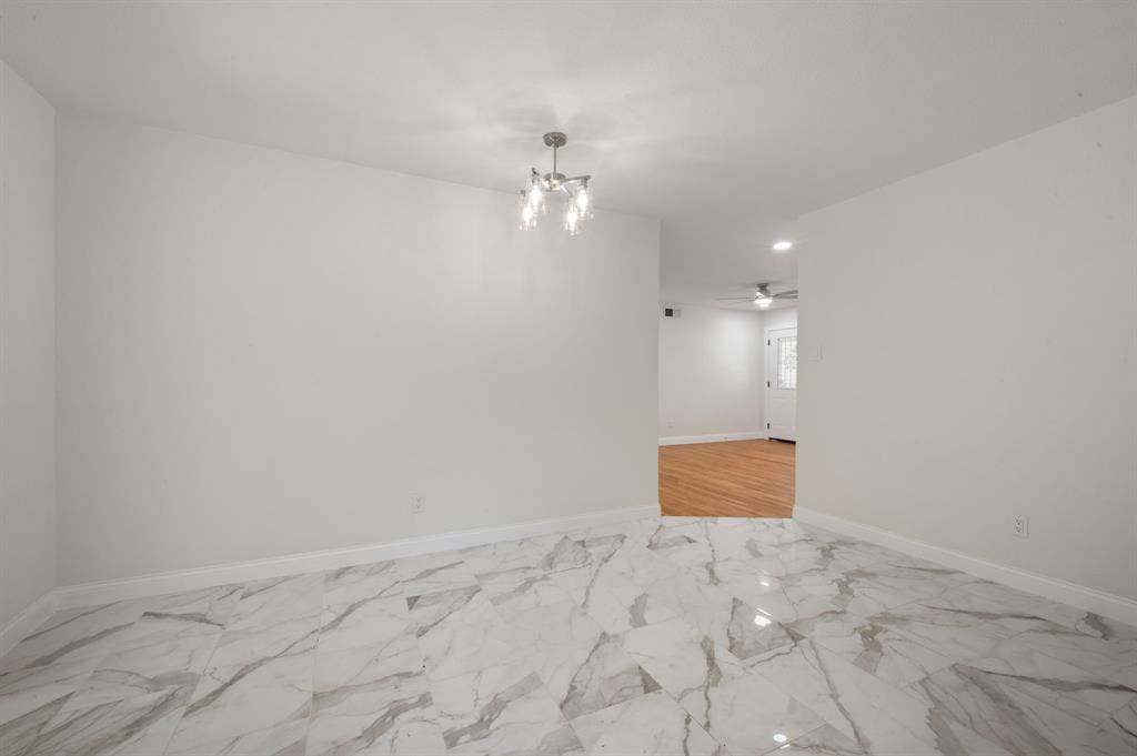 Polished large-format tile flooring with a marble-style pattern and a multi-light brushed-nickel chandelier