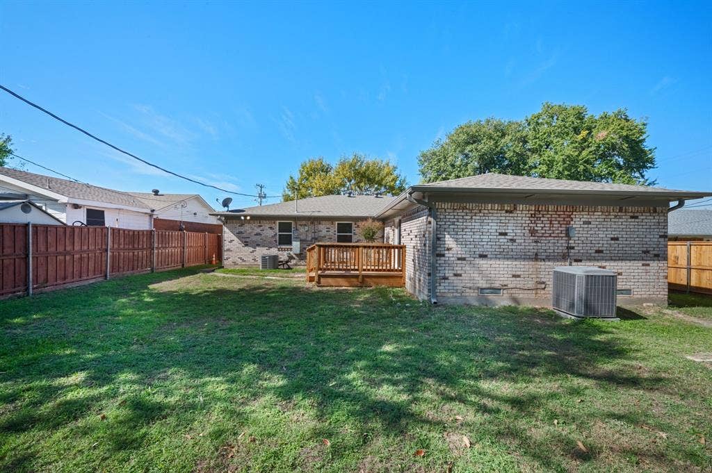 Brick exterior featuring a wooden deck, fenced perimeter, and dedicated yard space