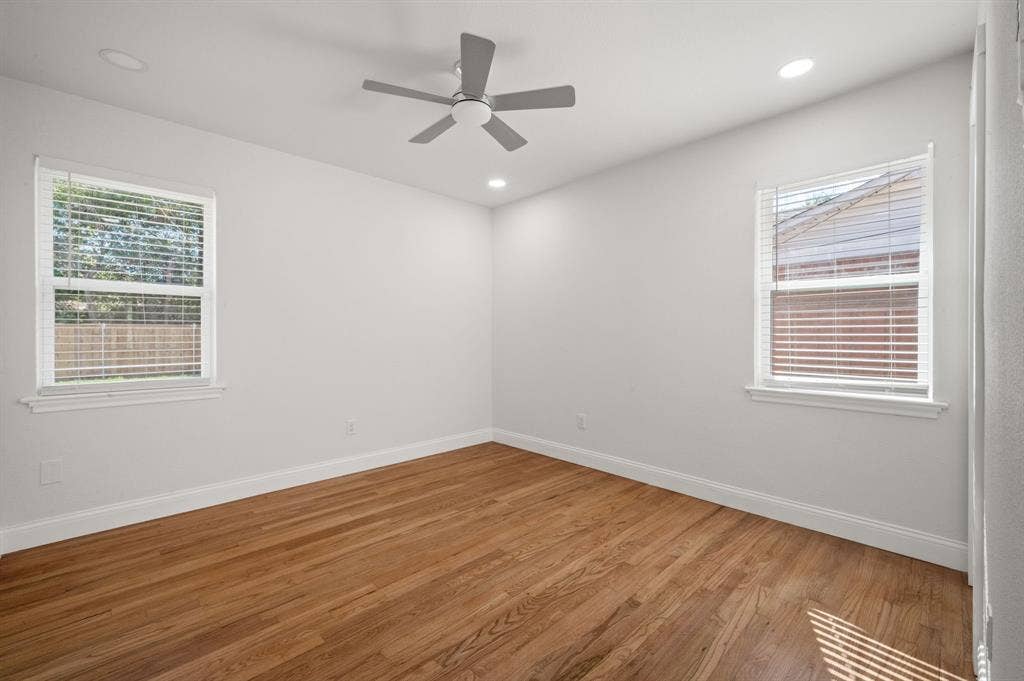 Interior space featuring wood-finish flooring, neutral walls, recessed lighting, and a centrally mounted ceiling fan with double-pane windows