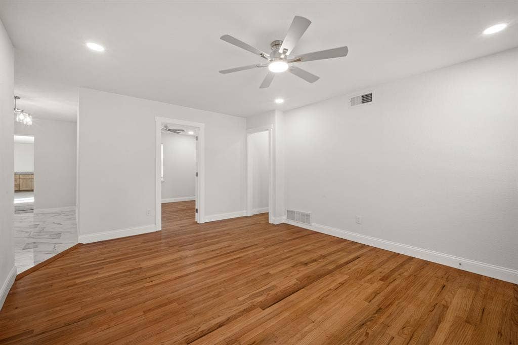 Interior space featuring wood-finish flooring, a ceiling fan with integrated lighting, and recessed ceiling illumination