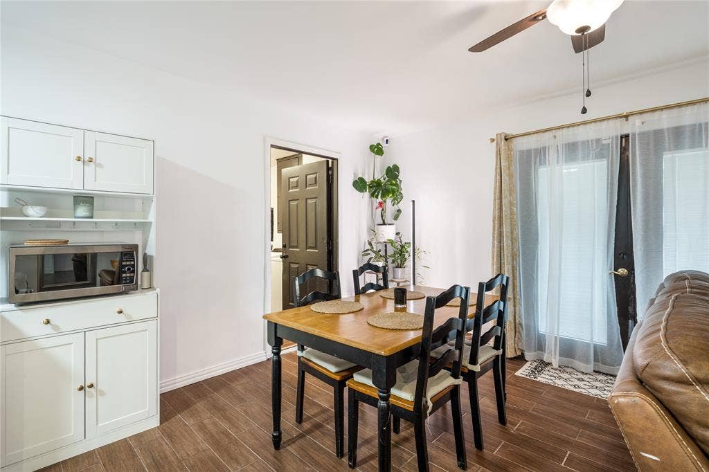 Built-in white cabinetry with open shelving, wood-finish flooring, and glass-paneled double doors leading to the exterior