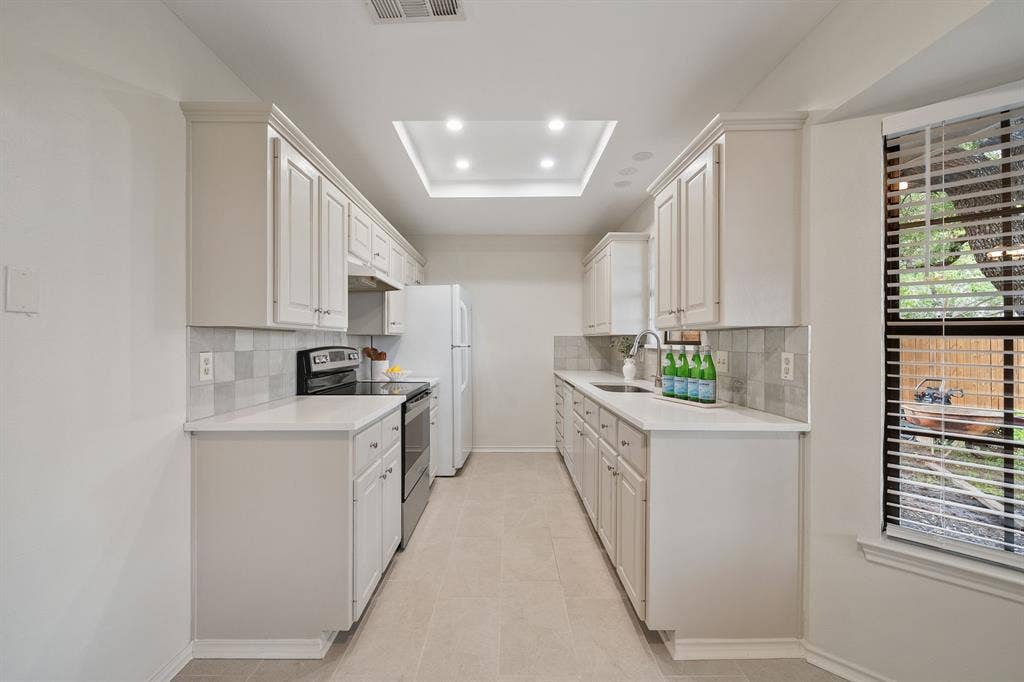 4043 Country Meadows Circle, Granbury, TX 76049 Kitchen featuring off-white cabinetry, solid-surface countertops, tile backsplash, tile flooring, and a recessed ceiling light fixture