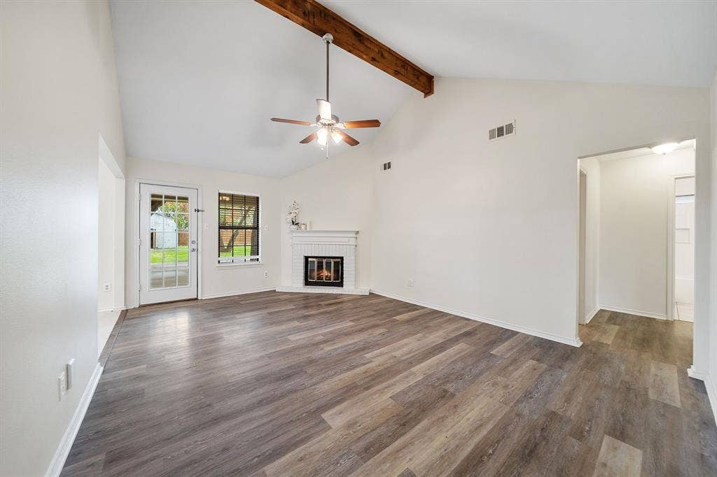 4043 Country Meadows Circle, Granbury, TX 76049 Vaulted ceiling with an exposed wood beam, wood-finish flooring, and a white masonry fireplace