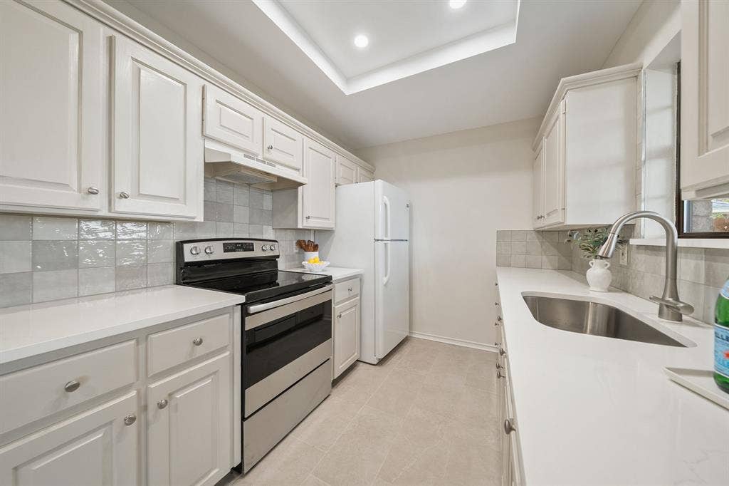 4043 Country Meadows Circle, Granbury, TX 76049 Kitchen featuring crisp white shaker-style cabinetry, solid-surface countertops, a tiled backsplash, stainless steel range, and recessed ceiling lighting