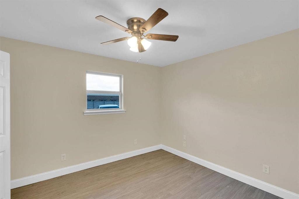 705 George Hopper Road, Midlothian, TX 76065 Room featuring neutral-toned walls, wood-finish flooring, a single-hung window, and a ceiling fan with integrated lighting