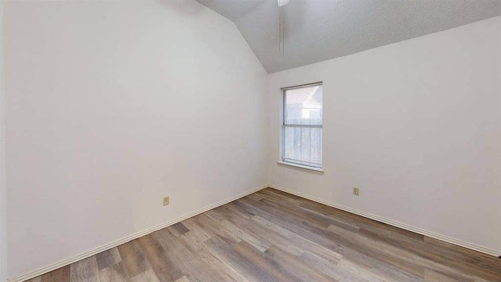 733 Rockett Lane, Cedar Hill, TX 75104 Room featuring vaulted ceilings, wood-finish flooring, and a single-pane window