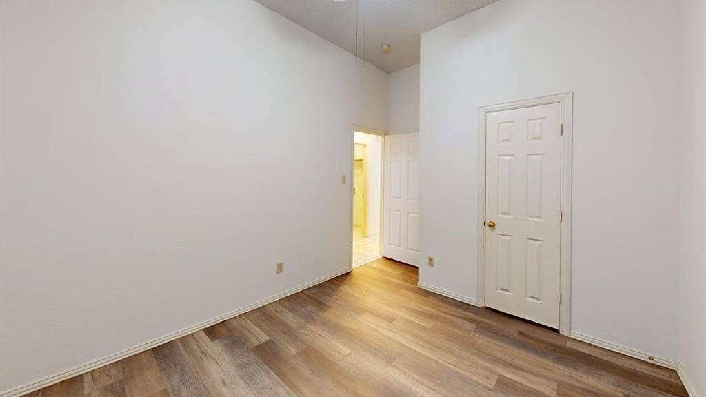 733 Rockett Lane, Cedar Hill, TX 75104 Interior room featuring high ceilings, wood-finish flooring, and a six-panel door
