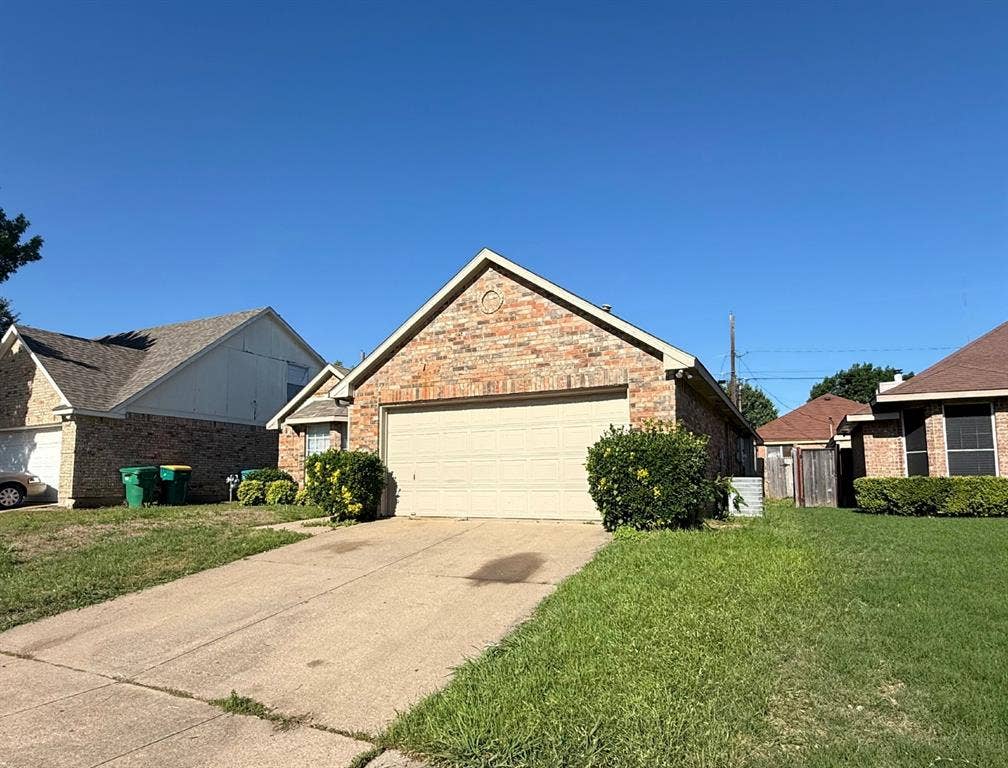 733 Rockett Lane, Cedar Hill, TX 75104 Brick exterior featuring a gabled roofline, concrete driveway, and attached two-car garage