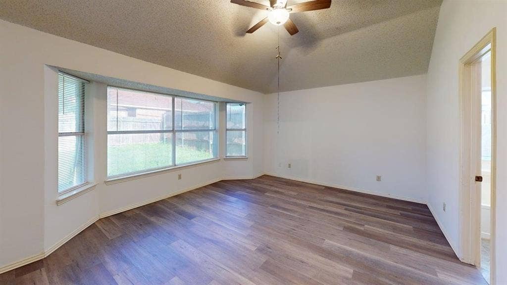 733 Rockett Lane, Cedar Hill, TX 75104 Room featuring a vaulted ceiling, wood-finish flooring, and a bay window