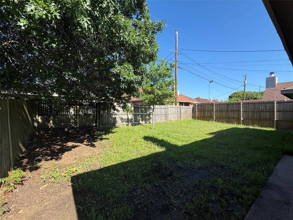 733 Rockett Lane, Cedar Hill, TX 75104 Backyard featuring a grass lawn, perimeter wood fencing, and mature trees