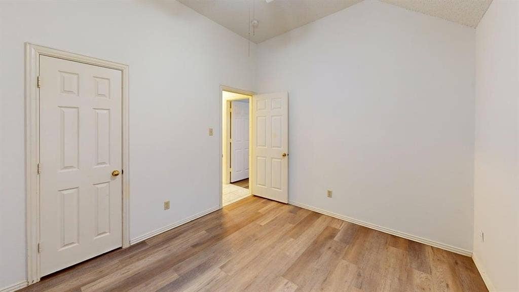 733 Rockett Lane, Cedar Hill, TX 75104 Interior room featuring vaulted ceilings, wood-finish flooring, and six-panel doors