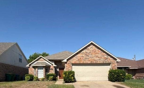 733 Rockett Lane, Cedar Hill, TX 75104 Single-story residence featuring a multi-textured brick exterior, a dual-gabled roofline, an attached two-car garage, and a front-facing bay window