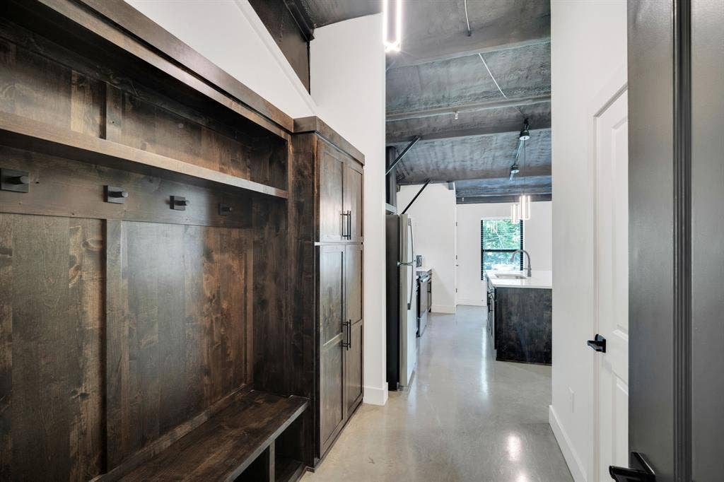 301 W Main Street, #252, Midlothian, TX 76065 Custom floor-to-ceiling wood cabinetry, polished concrete flooring, exposed industrial ceiling, and matte black hardware