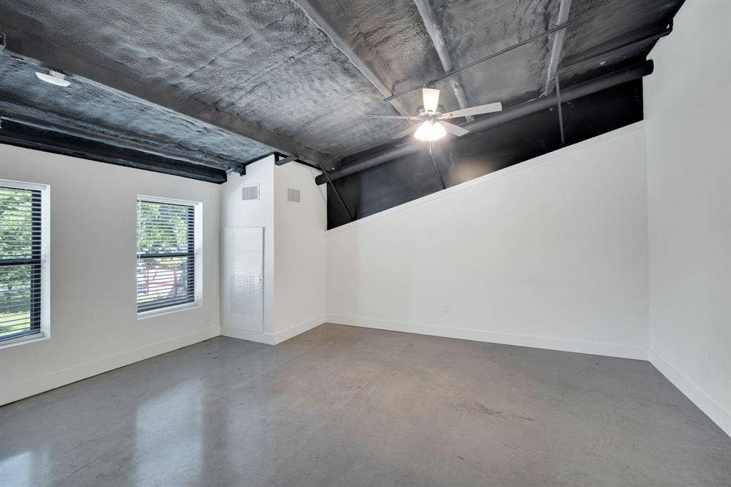 301 W Main Street, #252, Midlothian, TX 76065 Industrial-style space featuring exposed painted ceiling structure, concrete flooring, dual-pane windows, and a ceiling-mounted light fixture with fan