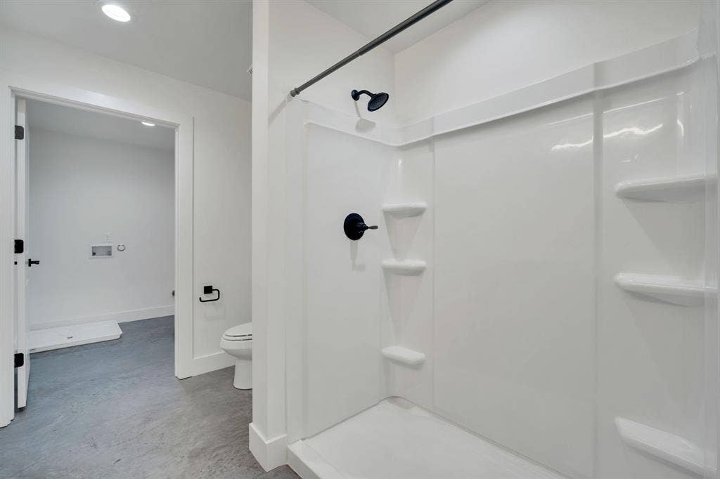 301 W Main Street, #252, Midlothian, TX 76065 Walk-in shower enclosure with integrated shelving, matte black fixtures, and neutral flooring