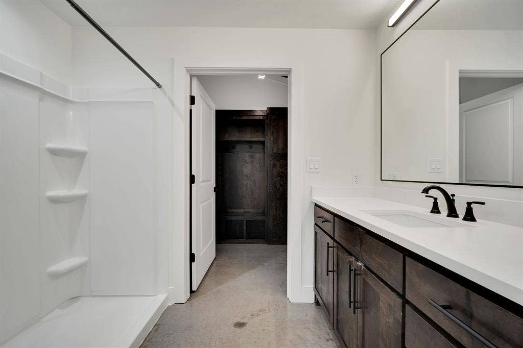 301 W Main Street, #252, Midlothian, TX 76065 Bathroom featuring a vanity with dark-stained cabinetry, a solid-surface countertop, and a widespread matte black faucet