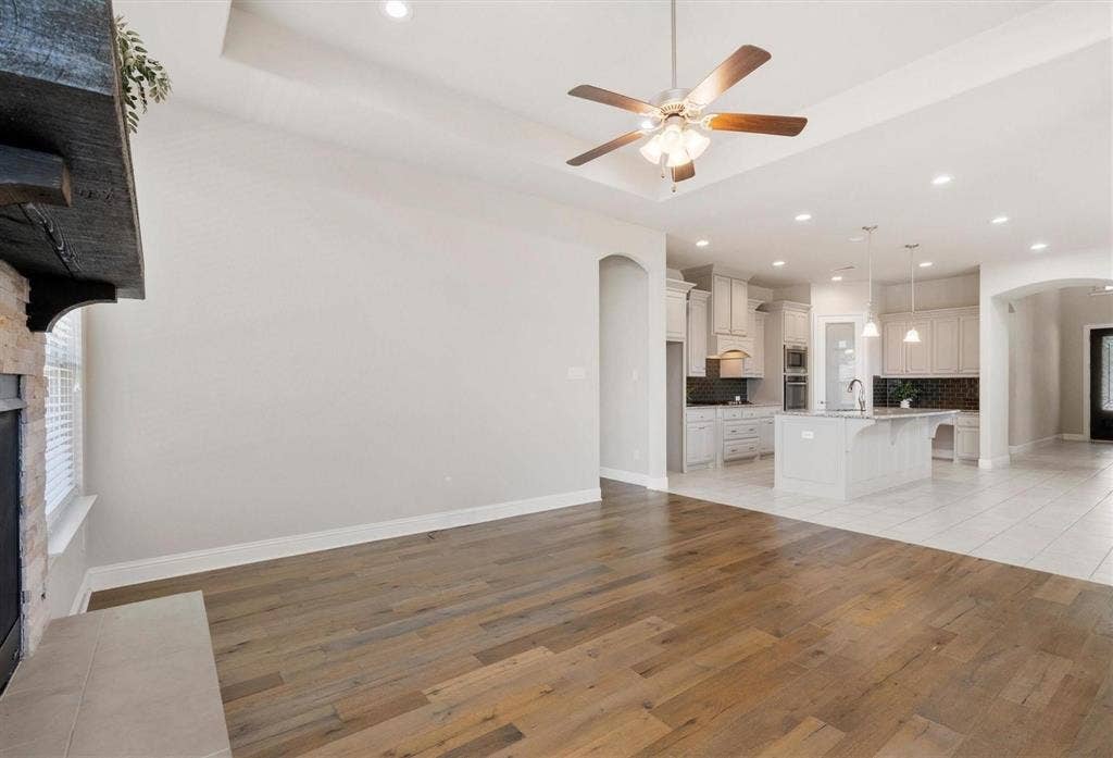 4109 Rainey Street, McKinney, TX 75070 Living area featuring wood-finish flooring, recessed lighting, and a tray ceiling