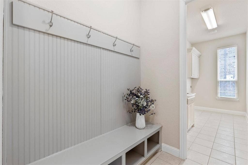 4109 Rainey Street, McKinney, TX 75070 Built-in mudroom bench featuring beadboard paneling, integrated coat hooks, and open lower storage cubbies