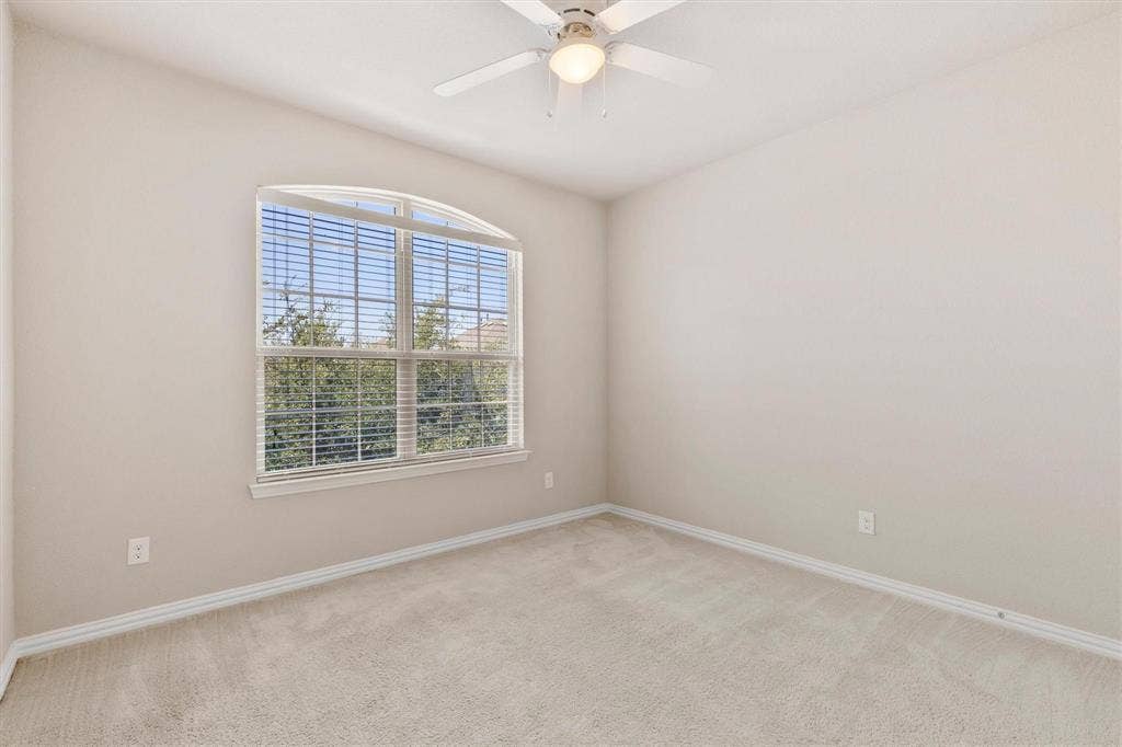 4109 Rainey Street, McKinney, TX 75070 Neutral wall finishes, carpeted flooring, arched window with horizontal blinds, and a white ceiling fan with integrated lighting