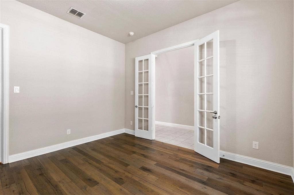 4109 Rainey Street, McKinney, TX 75070 Interior room featuring wood-finish flooring, neutral wall tones, and white-framed French doors