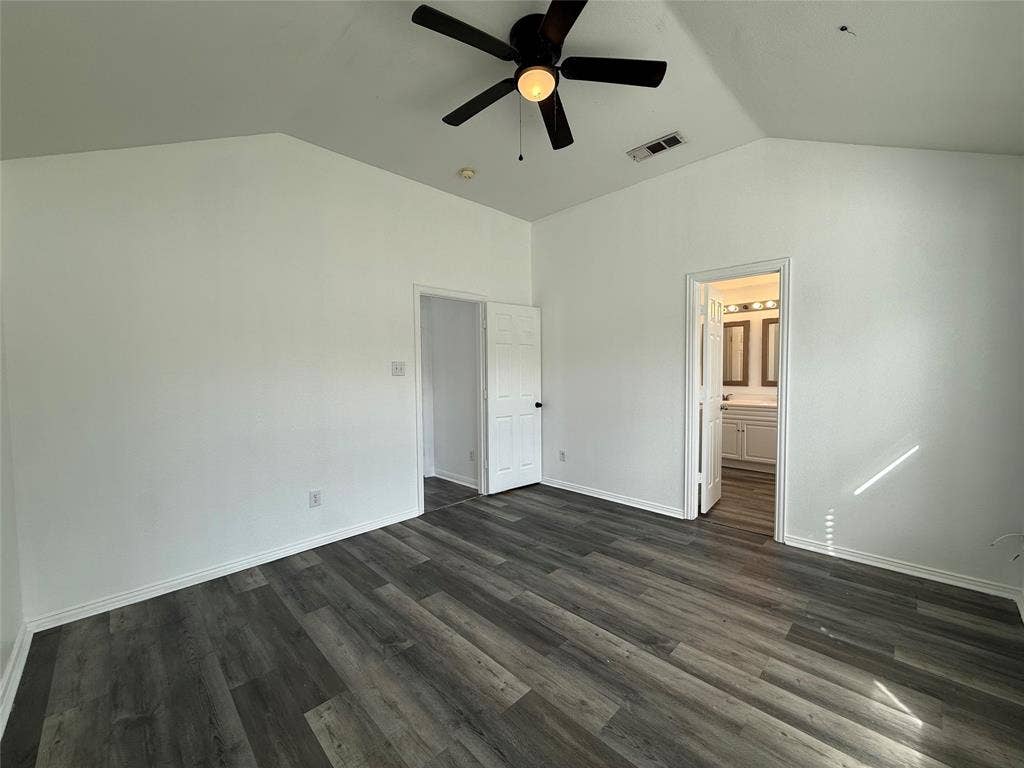 Vaulted ceiling featuring a central five-blade light fixture and durable wood-finish flooring