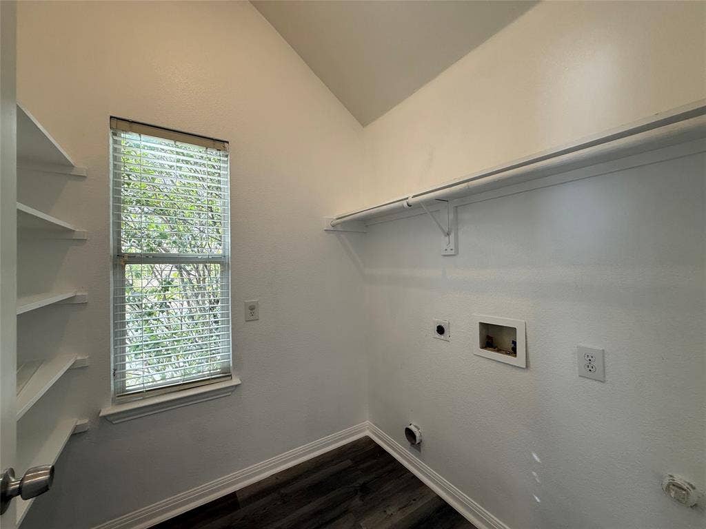 Laundry area featuring wood-finish flooring, vaulted ceilings, built-in shelving, and utility hookups