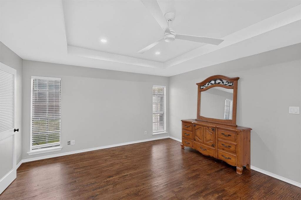 2413 Club Meadow Drive, Garland, TX 75041 Tray ceiling with recessed lighting and a ceiling fan, complemented by wood-finish flooring