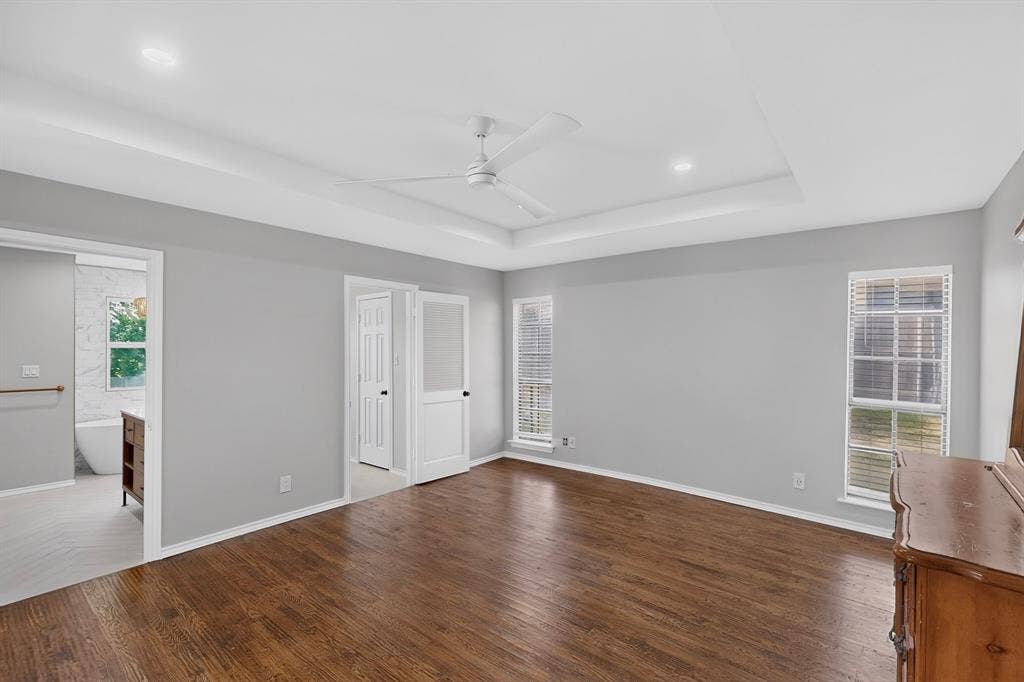 2413 Club Meadow Drive, Garland, TX 75041 Tray ceiling with recessed lighting, wood-finish flooring, and white ceiling fan