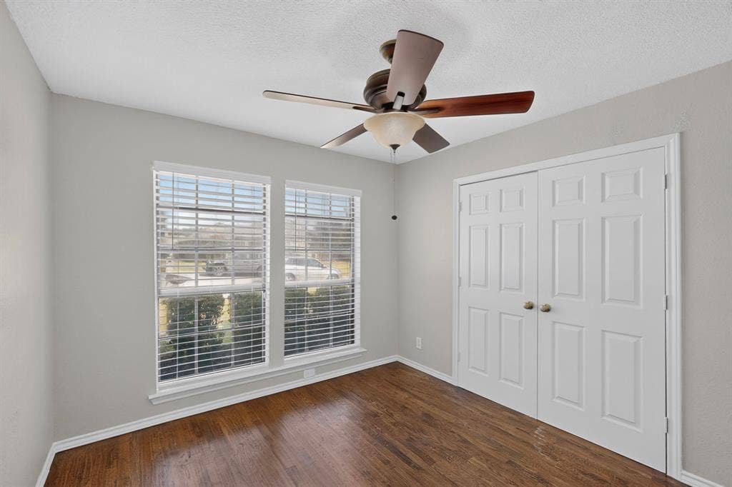2413 Club Meadow Drive, Garland, TX 75041 Hardwood-finish flooring, dual windows with blinds, bi-fold closet doors, and a ceiling fan with integrated lighting