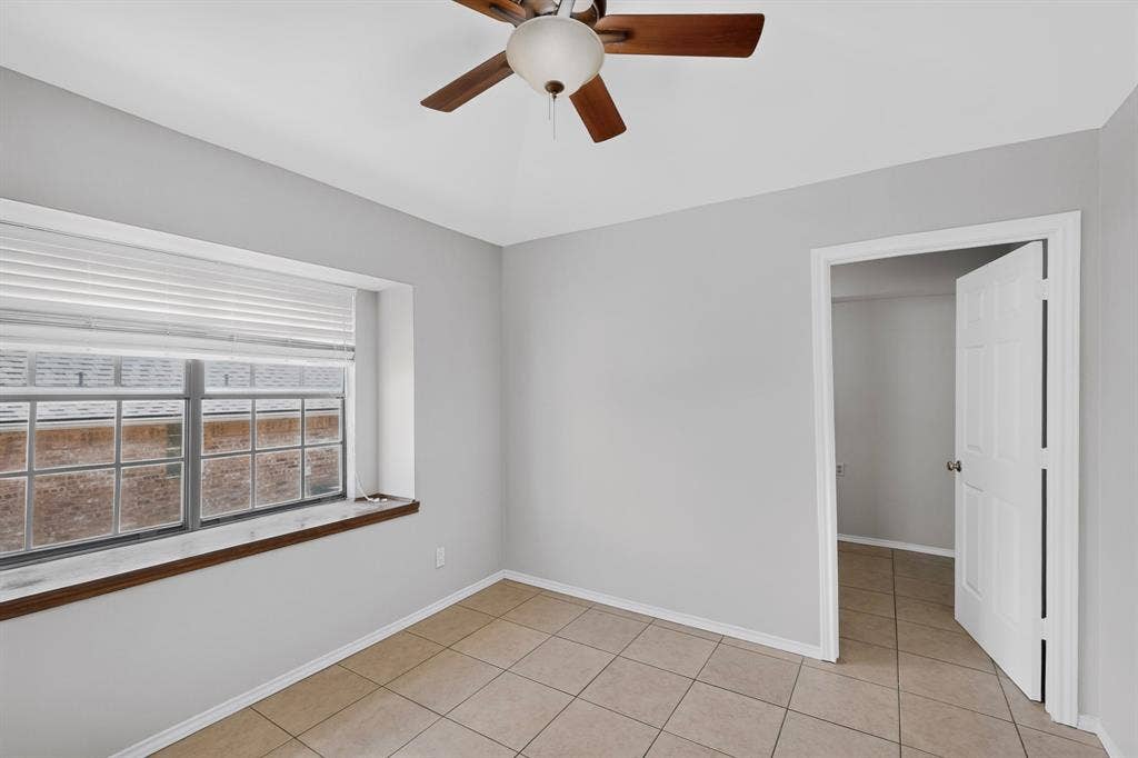 2413 Club Meadow Drive, Garland, TX 75041 Neutral wall color, ceiling fan, window with horizontal blinds, tile flooring, and white trim