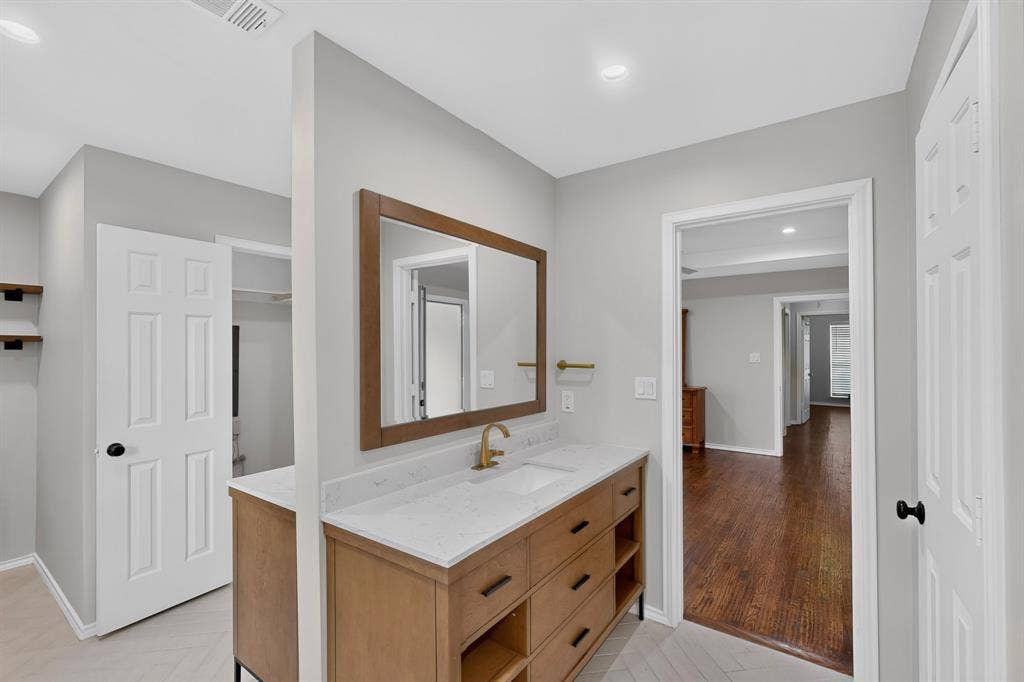 2413 Club Meadow Drive, Garland, TX 75041 Wood-finish double sided vanity with white countertop and integrated sink