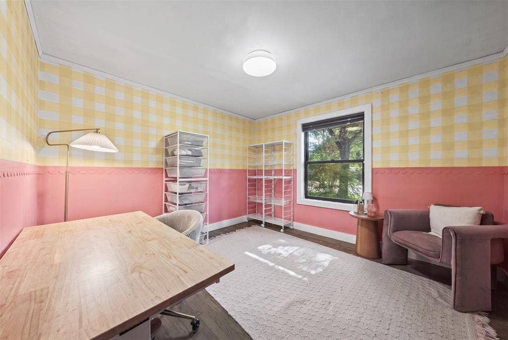 605 Ranier Circle, Garland, TX 75041 Room featuring dual-tone walls with gingham wallpaper, scalloped trim detailing, wood-finish flooring, and a single-pane window