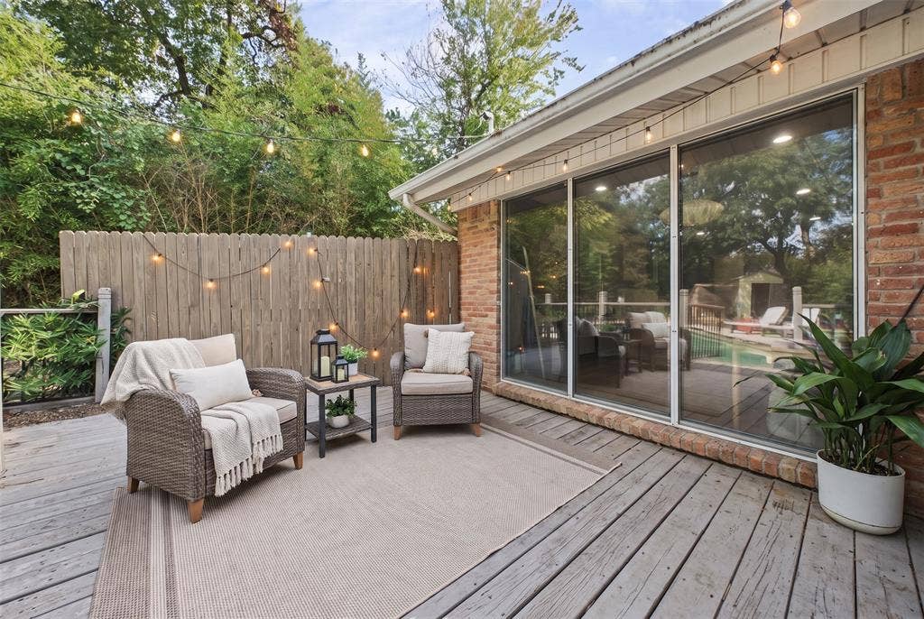 605 Ranier Circle, Garland, TX 75041 Wood-plank decking, floor-to-ceiling glass sliding doors, brick exterior siding, and perimeter privacy fencing