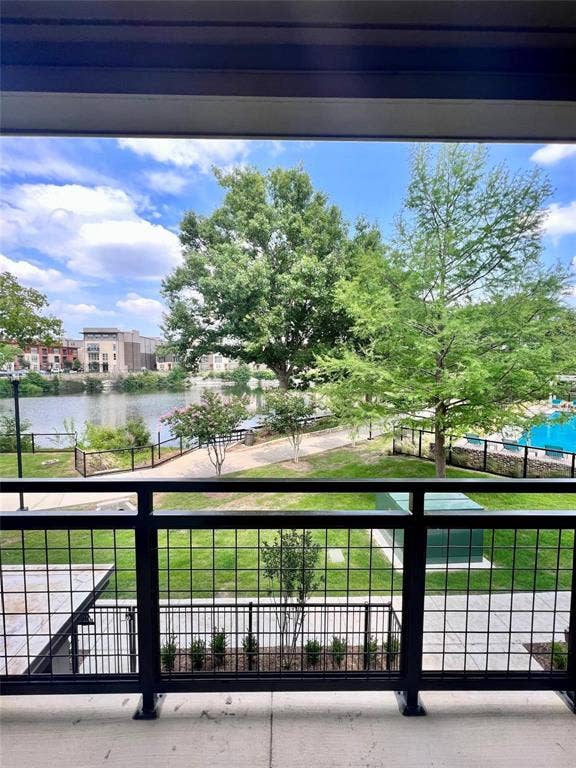 4020 McEwen Road, #4103, Farmers Branch, TX 75244 Balcony with black metal grid railing, concrete flooring, and surrounding trees