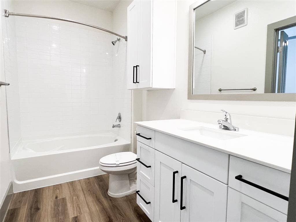 4020 McEwen Road, #4103, Farmers Branch, TX 75244 Bathroom featuring dark wood-type flooring, vanity, and shower / bath combination