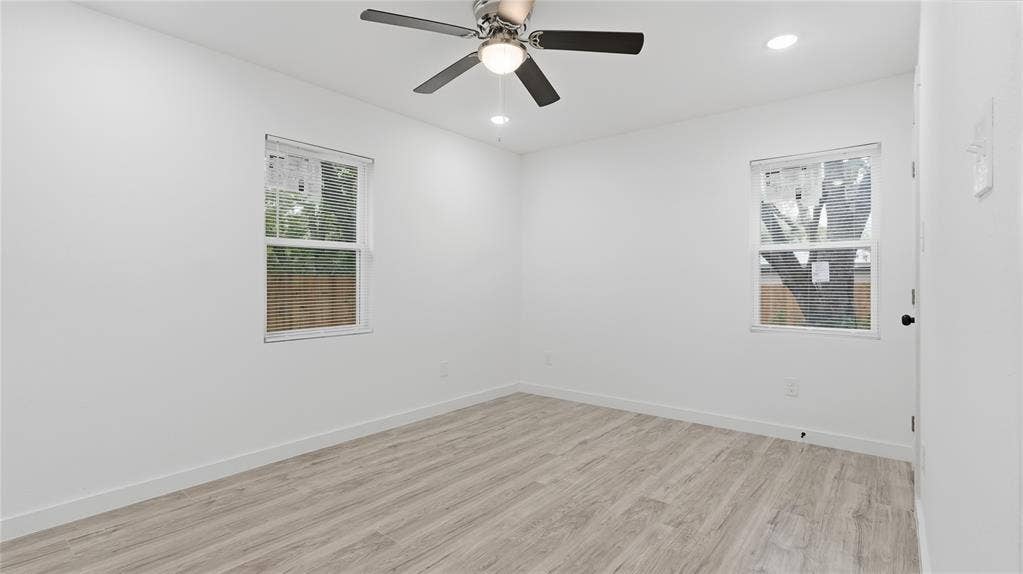 4330 Scottsdale Drive, Mesquite, TX 75150 Neutral interior featuring wood-finish flooring, two dual-pane windows, and a ceiling fan with integrated lighting