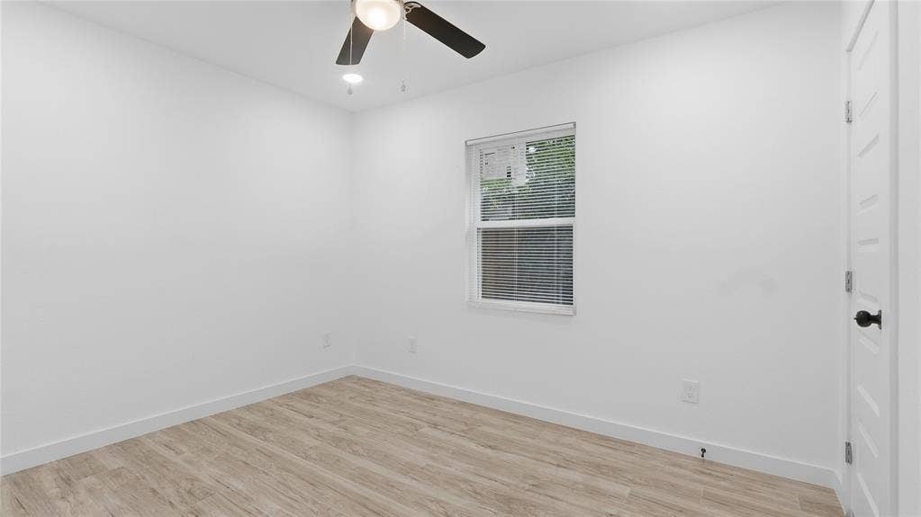 4330 Scottsdale Drive, Mesquite, TX 75150 Neutral-toned wood-finish flooring, white walls, single-hung window, and ceiling fan with integrated lighting