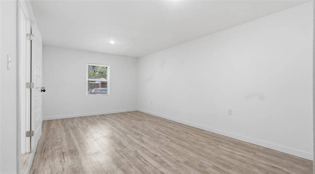 4330 Scottsdale Drive, Mesquite, TX 75150 Room interior featuring wood-finish flooring, white walls, recessed ceiling lighting, and a single-pane window